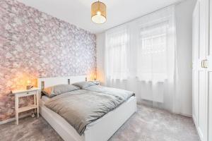 a bedroom with a white bed and a pink wall at 3-Zimmer-Wohnung in Leonberg in Leonberg