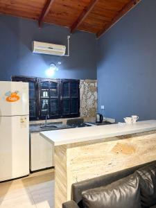 La cuisine est équipée d'un comptoir blanc et d'un réfrigérateur. dans l'établissement Complejo Lupita, cabañas y turismo, à Corrientes