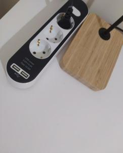 a remote control sitting next to a wooden board at Room II MCR Barreiro - Lisboa in Lavradio