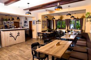 een restaurant met houten tafels en stoelen en een bar bij Valnovka Wellness Hotel in Kamenice