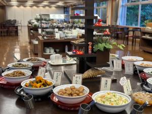 - un buffet avec des bols de nourriture sur une table dans l'établissement Takinoyu Hotel, à Tendō