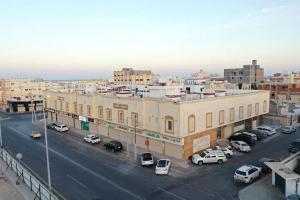 une ville avec des voitures garées dans un parking dans l'établissement فندق حياة تاون املج 1, à Umm Lajj