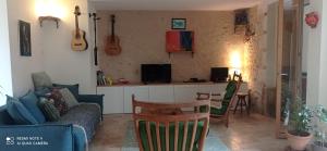 ein Wohnzimmer mit einem Sofa und einem Tisch in der Unterkunft Maison au bord d'un ruisseau in Pontigné