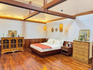 um quarto com uma cama e piso em madeira em Manil Home Stay - 3 Beds Room em Siem Reap
