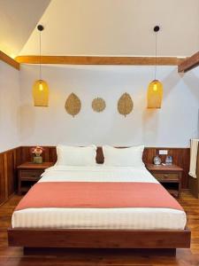 a bedroom with a bed with two lights on the wall at Manil Home Stay - 3 Beds Room in Siem Reap