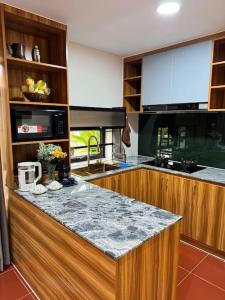 uma cozinha com um balcão de granito num quarto em Manil Home Stay - 3 Beds Room em Siem Reap