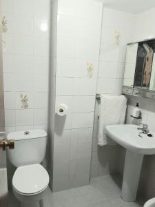 een witte badkamer met een toilet en een wastafel bij Casa Adriana, balcon y parking Habitacion en piso compartido in Almuñécar