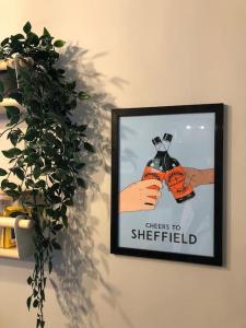 a picture hanging on a wall with a plant at Studio 77 - Central. Free on street parking. in Sheffield