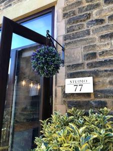 una señal en el lateral de un edificio con una planta en Studio 77 - Central. Free on street parking. en Sheffield