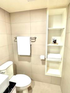 ein weißes Bad mit einem WC und einem Spiegel in der Unterkunft 之跡 台北 in Taipeh