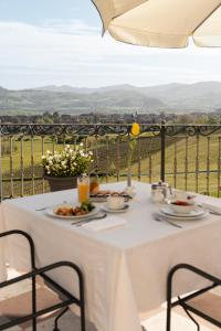 a white table with plates of food on a balcony at Hotel Villa La Bollina in Serravalle Scrivia