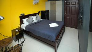 een slaapkamer met een bed met een blauw dekbed bij HIVEE-1 Rooms & Living AC in Hyderabad