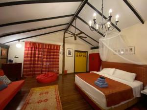 a bedroom with a bed and a chandelier at Experience Island Heritage Home in Pantai Kok