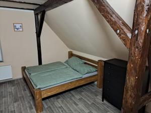 a small bedroom with a bed in a attic at Chata Na Rozcestí in Loučná pod Klínovcem