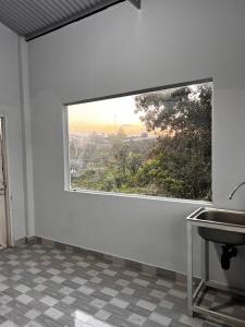 a bathroom with a large window and a sink at Garden Homestay in Di Linh