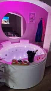 bañera de hidromasaje en una habitación rosa con 2 tazones en La Dimora di Venere, en Castellana Grotte