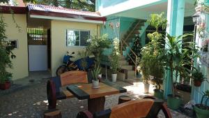 un patio con mesa, sillas y plantas en Village Guest House en Casboran