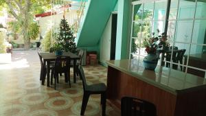 un comedor con mesa y sillas y un árbol de Navidad en Village Guest House en Casboran