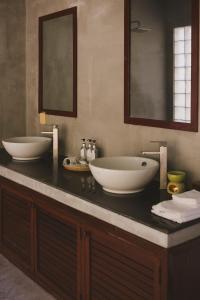 a bathroom with two sinks on a black counter at Villa La Plantation in Kampot