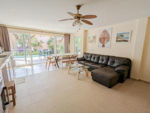 ein Wohnzimmer mit Sofa und Tisch in der Unterkunft Koh Chang Pool Villa - by KohChangVillas in Ko Chang