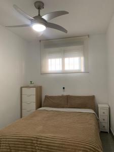 um quarto com uma cama e uma ventoinha de tecto em Apartamento Dreamplace em Finestrat