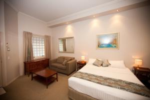 Habitación de hotel con cama y silla en Shangri-La Gardens en Brisbane