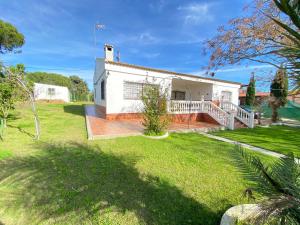 a white house with a porch and a yard at VILLA LÚA in Cartaya