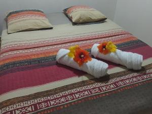 ein Bett mit zwei Handtüchern mit Blumen drauf in der Unterkunft Location Hibiscus in Pointe-Noire