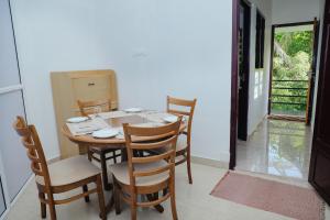 a dining room with a wooden table and chairs at Sankalpa Homestay in North Paravur