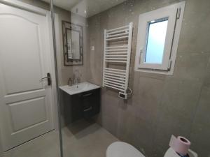 ein Bad mit einem Waschbecken, einem WC und einem Fenster in der Unterkunft Le grain de sel 