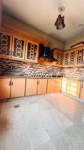 a kitchen with wooden cabinets and a chandelier at QueensLand villa near Islamabad airport & motorway in Rawalpindi