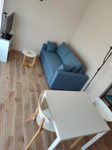 ein Wohnzimmer mit einem blauen Sofa und einem Tisch in der Unterkunft Maison d'hôtes calme proche village in Bédoin
