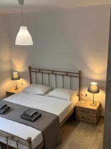 a bedroom with a bed and two lamps on tables at The Eagle Merchia Mykonos in Merchia Beach +56 photos