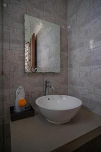 a bathroom with a white sink and a mirror at Wiras Village in Canggu