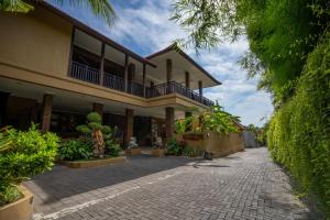 een gebouw met een loopbrug ervoor bij Wiras Village in Canggu