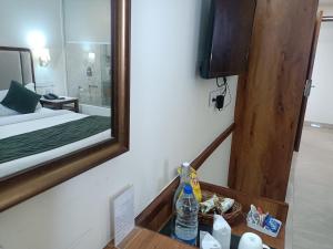 a bathroom with a mirror and a bed and a sink at zoz Chandigarh in Chandīgarh