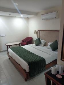 um quarto com uma cama grande e um cobertor verde em zoz Chandigarh em Chandīgarh