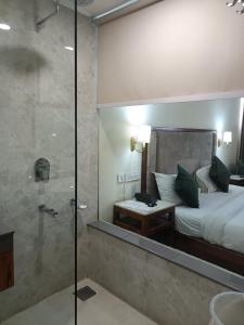 um quarto com uma cama e uma cabina de duche em vidro em zoz Chandigarh em Chandīgarh