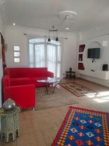 uma sala de estar com um sofá vermelho e uma mesa em Villa Quiet Place em Luxor
