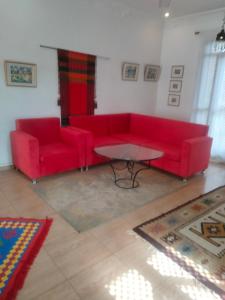 ein Wohnzimmer mit einem roten Sofa und einem Tisch in der Unterkunft Villa Quiet Place in Luxor