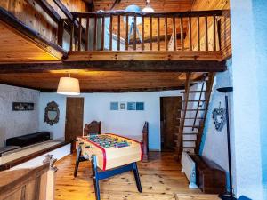 Zimmer mit einem Tisch und einer Holztreppe in der Unterkunft Bergerie Ariégeoise in Ustou