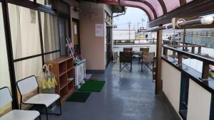 a room with a balcony with chairs and a table at 和室+洋室+日本酒飲放題/Premier Guest House 