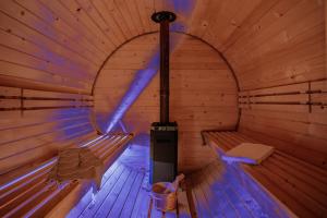 an inside of a wooden sauna with a stove at Osada Zbójnicka Turnia in Kościelisko