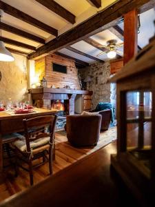 a living room with a table and a fireplace at Bergerie Ariégeoise in Ustou