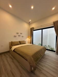 a bedroom with a large bed and a large window at Relax Homestay - Đảo Phú Quý in Cu Lao Thu