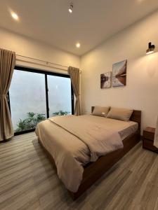 a bedroom with a large bed and a large window at Relax Homestay - Đảo Phú Quý in Cu Lao Thu