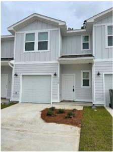 uma grande casa branca com duas portas de garagem em Admiral's Quarters Suite em Pensacola