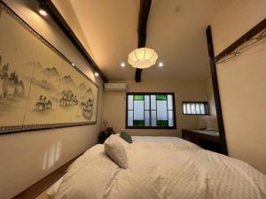 Imakumano Terrace - Mokubei An 木米庵 في كيوتو: غرفة نوم فيها سرير ابيض كبير