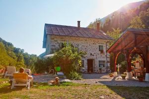 a man sitting in a chair in front of a house at Pri Macku in Tolmin