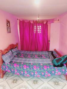 a bedroom with a bed with a pink curtain at J Rooms&Dormentary in Madurai